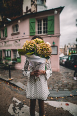 Woman holding a bouquet of peonies in Paris