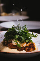 Close Up Chicken Parmigiana With Mashed Potatoes Covered With Fresh Arugula And Topped With Cheese