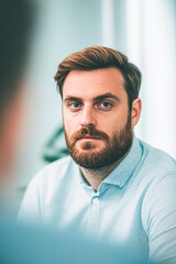 Obraz premium A thoughtful man with a beard gazes intently, creating a professional atmosphere.