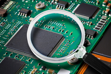 Hard drive with damaged electronic componensts - concept image seen through a magnifying glass