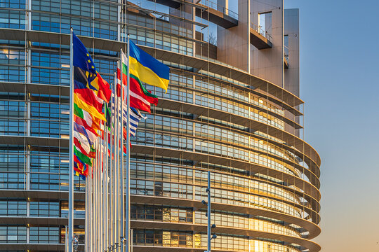 Flaggen der Europ&auml;ischen Union und ihrer Mitgliedstaaten wehen vor dem Europ&auml;ischen Parlament in Stra&szlig;burg.  Die Szene strahlt Stabilit&auml;t und Zusammenhalt aus.