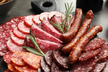 Different smoked sausages slices served on grey table, closeup