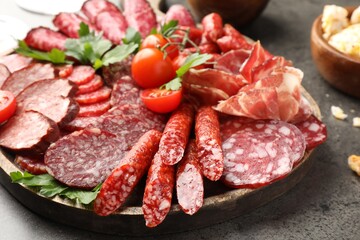 Different smoked sausages slices served on grey table, closeup