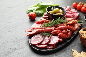Different smoked sausages and other snacks on black table, closeup. Space for text