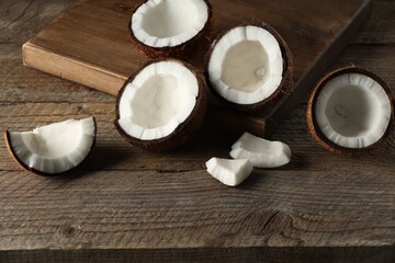 Pieces of cracked coconuts on wooden table