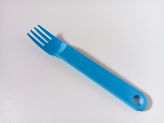 Close up of blue plastic fork isolated on white background.