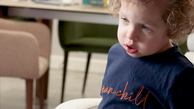 Little boy of 3 years old watching cartoon in room closely. Kids and lifestyle. Emotional intelligence. 