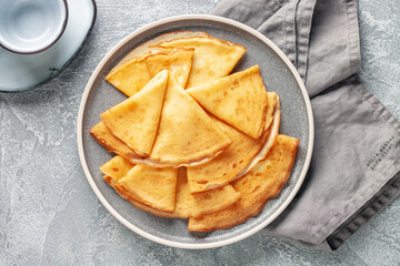 Crepes (Russian Blini) on grey background,. Homemade thin fresh crepes for breakfast or dessert. Top view