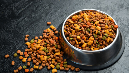 Bowl of pet food. Nutritious healthy diet pet food. On a black textured background.