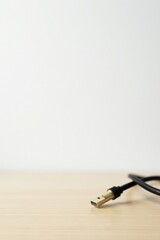 Naklejka premium White background with a black twisted isolated cable on wooden desk, white, background