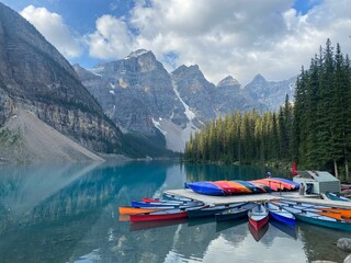 Stunning view of the Moraine Lake canoe dock, where colorful canoes rest on the turquoise waters