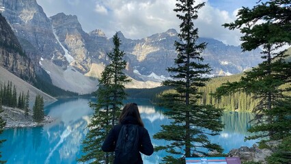 Woman stands at a breathtaking lookout, gazing at the iconic Moraine Lake