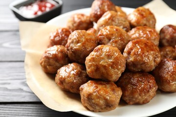 Many delicious meatballs on dark wooden table, closeup