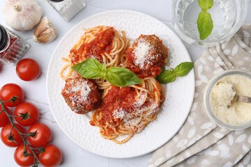 Delicious pasta with meatballs, cheese and tomatoes on light textured table, flat lay
