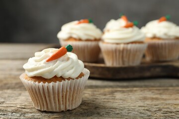 Delicious carrot cupcakes on wooden table, closeup