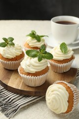 Delicious carrot cupcakes with mint and coffee on light textured table, closeup