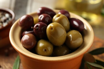 Tasty olives in bowl on table, closeup