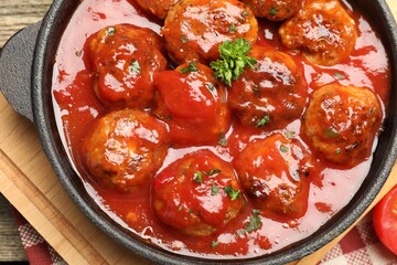 Delicious meatballs with tomato sauce in baking dish on table, top view