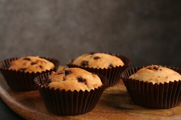 Delicious muffin with chocolate chips on table, closeup