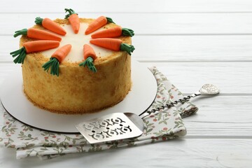 Delicious homemade carrot cake and server on white wooden table