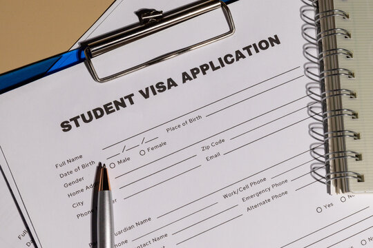 A neatly placed student visa application on a clipboard, illustrating the legal paperwork required for academic travel.

