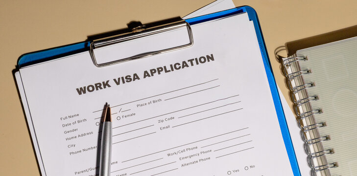 A work visa application document placed on a clipboard, symbolizing the journey towards working in a foreign country.