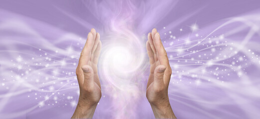 Light worker sensing double Fibonacci high vibration healing energy field  - male parallel hands against a lilace bacgkround and copy space for spiritual message
