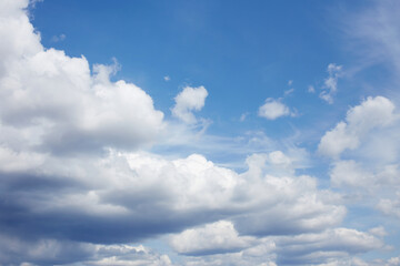 White cumulus clouds on a blue sky. Beautiful natural sky background.