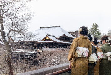 Young women dressed in kimono viewing Kiyomizudera temple in snow, Kyoto, Japan