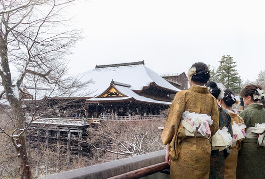 Young women dressed in kimono viewing Kiyomizudera temple in snow, Kyoto, Japan