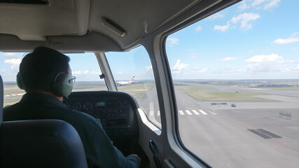 View from the window of an airplane with a pilot in the cockpit