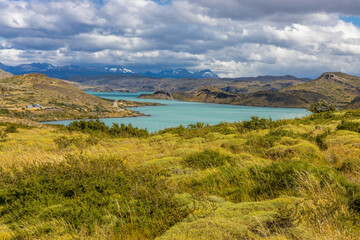 Torres del Paine national park mountain landscape in Patagonia, Chile. Los Cuernos and Torres del Paine peak granite towering summits on a nasty and sunny day above the blue water lake in the Andes