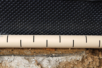 Tuyaux d'évacuation pluvial et eaux usées de la maison et membrane de fondation et soubassement...