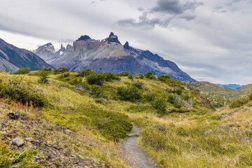Fototapeta premium Torres del Paine national park mountain landscape in Patagonia, Chile. Los Cuernos and Torres del Paine peak granite towering summits on a nasty and sunny day above the blue water lake in the Andes