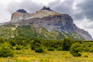Naklejka premium Torres del Paine national park mountain landscape in Patagonia, Chile. Los Cuernos and Torres del Paine peak granite towering summits on a nasty and sunny day above the blue water lake in the Andes