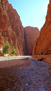 Scenic mountain gorge with steep rocky cliffs under a clear blue sky in Todra Gorge, Morocco