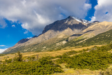 Fototapeta premium Torres del Paine national park mountain landscape in Patagonia, Chile. Los Cuernos and Torres del Paine peak granite towering summits on a nasty and sunny day above the blue water lake in the Andes