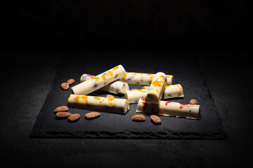 white chocolate bars with salted almonds, on dark background