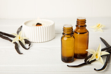 Bottle of vanilla essential oil with vanilla flower on textured background. aromatic vanilla beans. Vanilla extract. Spa concept. Beauty and care. Place for text. Copy space.