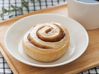 白い皿の上のシナモンロールとホットコーヒー