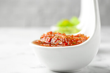 Sauce boats with salsa on white marble table, selective focus