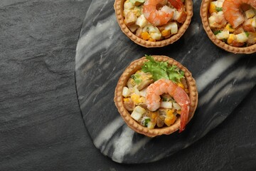 Tartlets with delicious filling on black table, top view. Space for text
