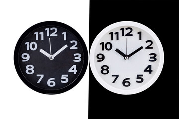Dual Clocks: A captivating juxtaposition of time, showcasing two identical clocks with a striking contrast in color, one black, one white, against a divided background.