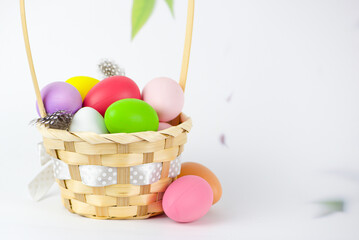 Basket with colorful eggs on a white background, Easter concept