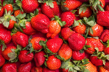 Fresh ripe strawberries with green leaves background