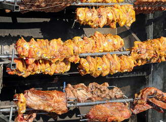 skewer with chicken beef and pork rotating on the huge rotisserie at the village festival restaurant