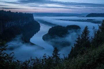 Fototapeta premium Foggy valley with a river winding through