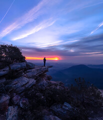 Montañero en la cima observando el precioso amanecer.