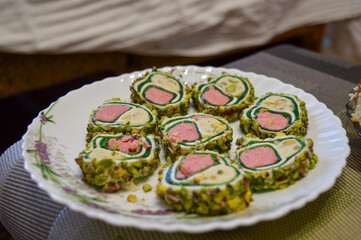 plate of beautiful Turkish sweet roll slices pistachios homemade gourmet culinary Middle Eastern...