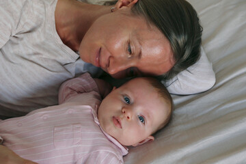 Portrait of mother and child bonding in bed. Close up, background.
